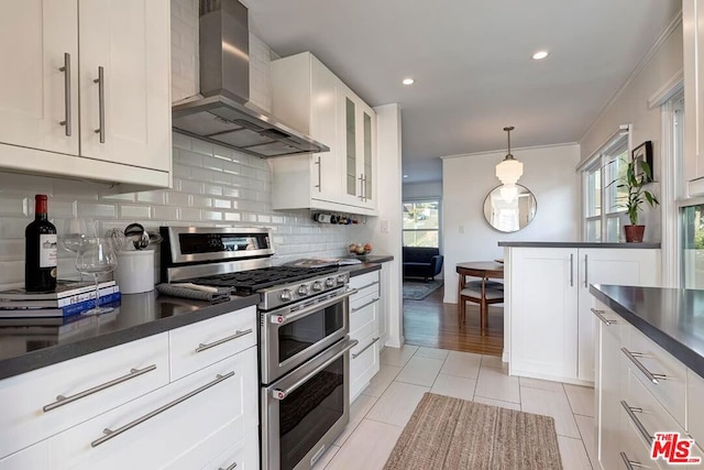 kitchen featuring white cabinetry, double oven range, exhaust hood, and light tile patterned floors