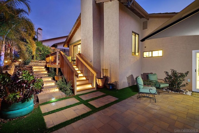 back house at dusk with a patio