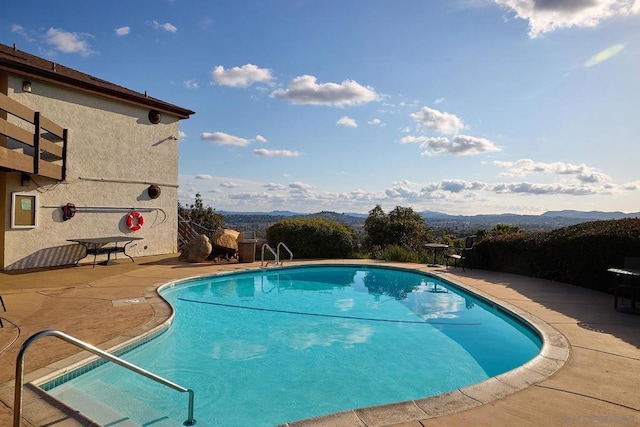 view of pool with a mountain view and a patio