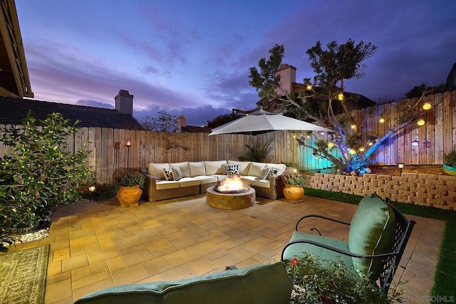 patio terrace at dusk featuring an outdoor living space with a fire pit