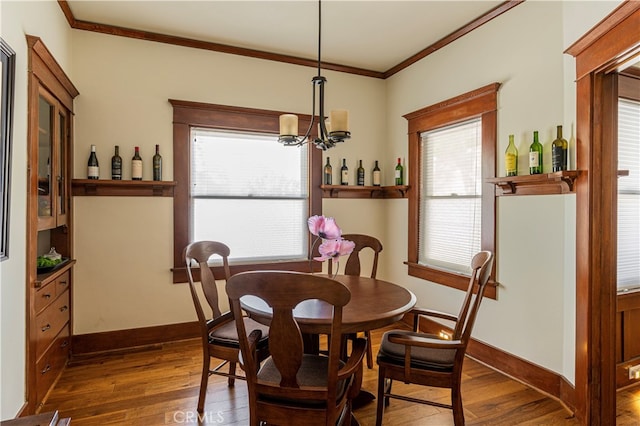 dining room with dark wood-type flooring, plenty of natural light, and crown molding