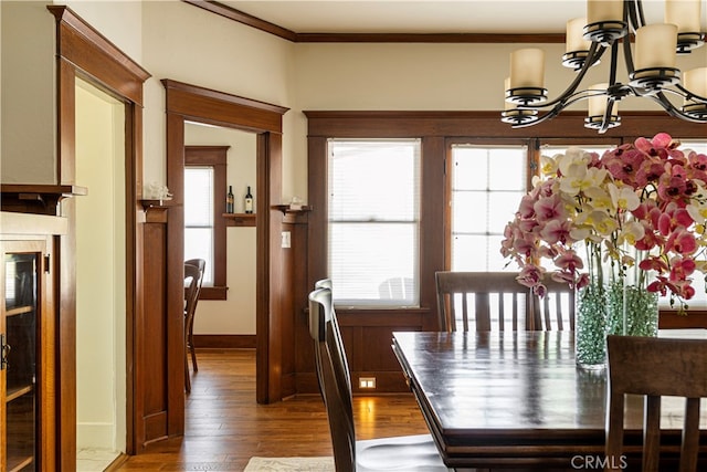 dining room with crown molding, a chandelier, and hardwood / wood-style flooring