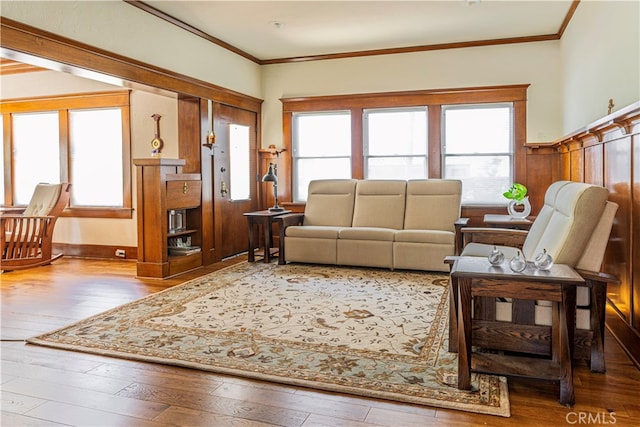 living room with crown molding, a healthy amount of sunlight, and hardwood / wood-style floors