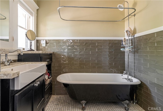 bathroom featuring tile patterned flooring, vanity, a tub, and tile walls