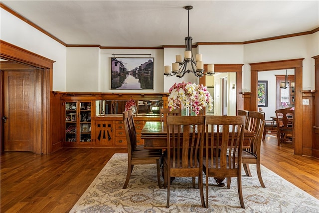 dining room featuring ornamental molding, dark hardwood / wood-style floors, and a notable chandelier