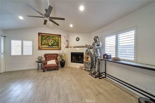 sitting room featuring lofted ceiling with beams, ceiling fan, a baseboard heating unit, and light hardwood / wood-style floors