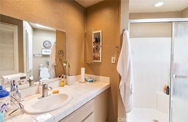 bathroom featuring vanity and an enclosed shower