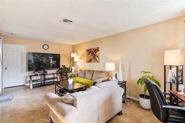 tiled living room featuring a textured ceiling