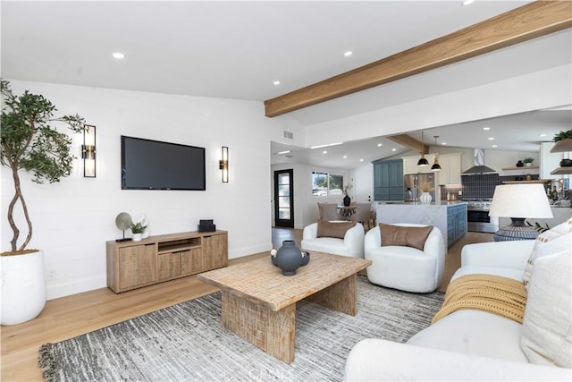 living room with vaulted ceiling with beams and light hardwood / wood-style flooring