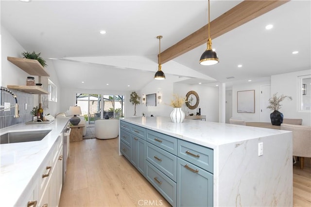 kitchen featuring sink, white cabinetry, hanging light fixtures, vaulted ceiling with beams, and light stone counters