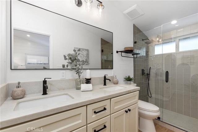 bathroom with vanity, a shower with door, and toilet