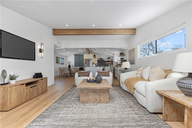 living room with vaulted ceiling with beams and hardwood / wood-style flooring