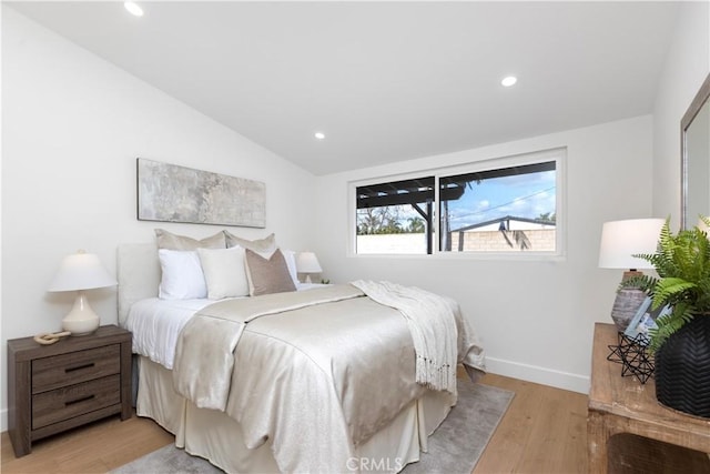 bedroom with light hardwood / wood-style floors and vaulted ceiling