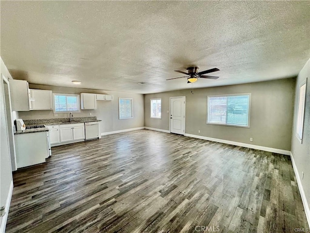 unfurnished living room with ceiling fan, dark hardwood / wood-style flooring, sink, and a textured ceiling