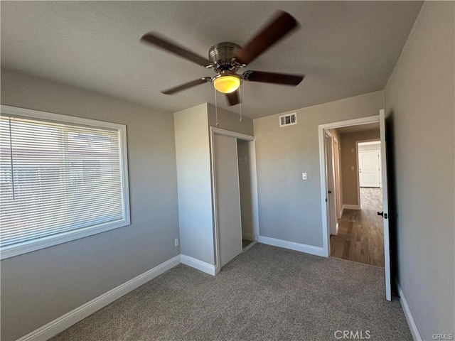 unfurnished bedroom featuring carpet floors, ceiling fan, and a closet