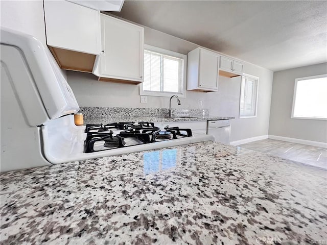 kitchen featuring white cabinetry, sink, light stone counters, and dishwasher