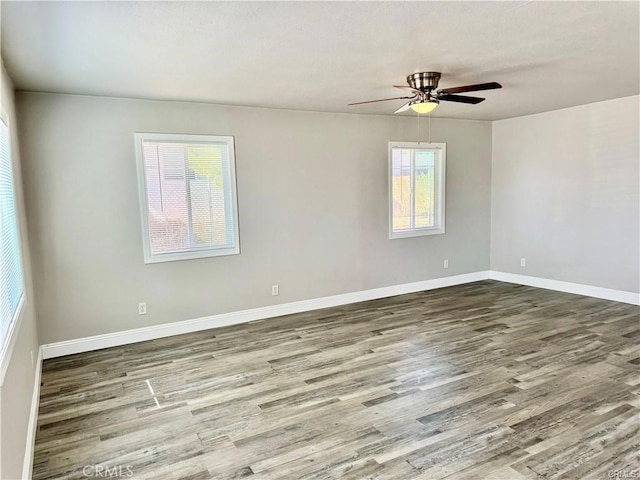 unfurnished room with ceiling fan, hardwood / wood-style floors, and a wealth of natural light