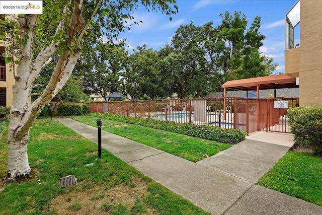 view of home's community featuring a swimming pool and a lawn