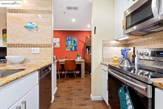 kitchen with white cabinetry, backsplash, dark hardwood / wood-style floors, and appliances with stainless steel finishes