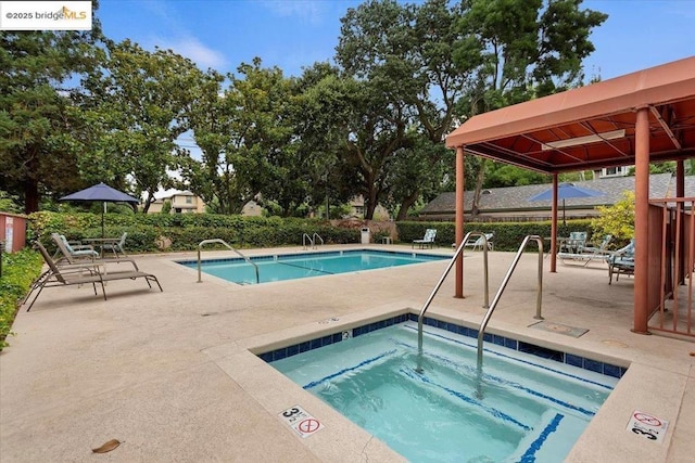 view of pool featuring a hot tub and a patio area