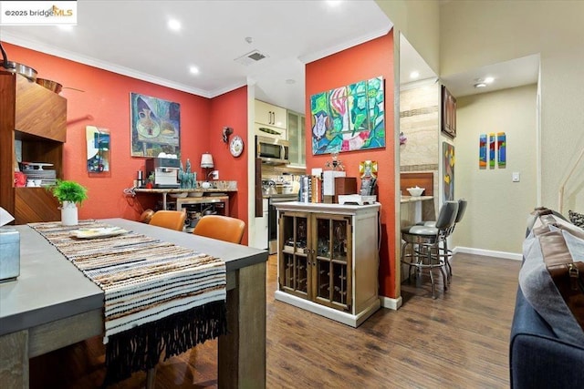 dining area with hardwood / wood-style floors and crown molding