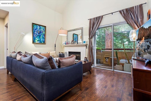 living room with dark wood-type flooring and a fireplace