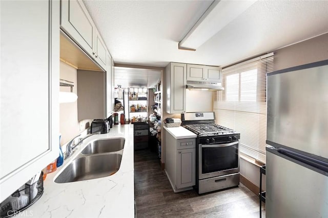 kitchen featuring appliances with stainless steel finishes, sink, gray cabinetry, and a textured ceiling