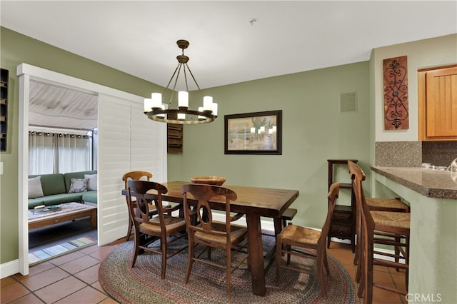 dining area featuring an inviting chandelier and light tile patterned flooring