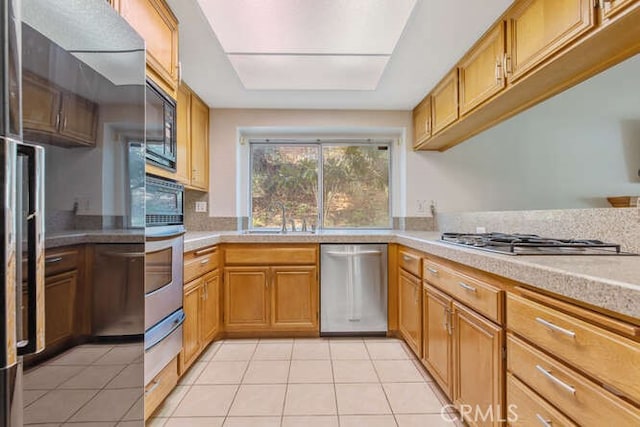 kitchen with light tile patterned flooring, stainless steel appliances, and sink