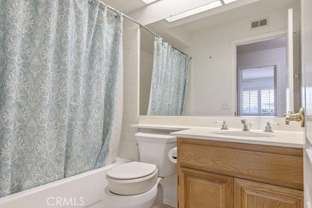 full bathroom with vanity, shower / bath combo with shower curtain, and toilet