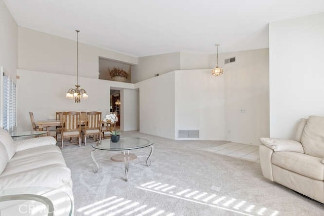 carpeted living room with an inviting chandelier and high vaulted ceiling