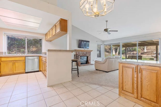 kitchen with ceiling fan with notable chandelier, decorative light fixtures, dishwasher, a brick fireplace, and light carpet