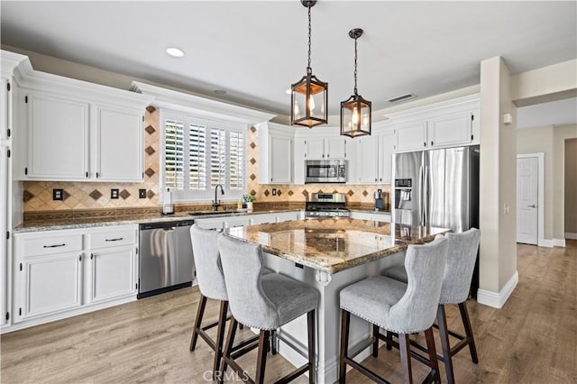 kitchen with white cabinetry, appliances with stainless steel finishes, and a center island