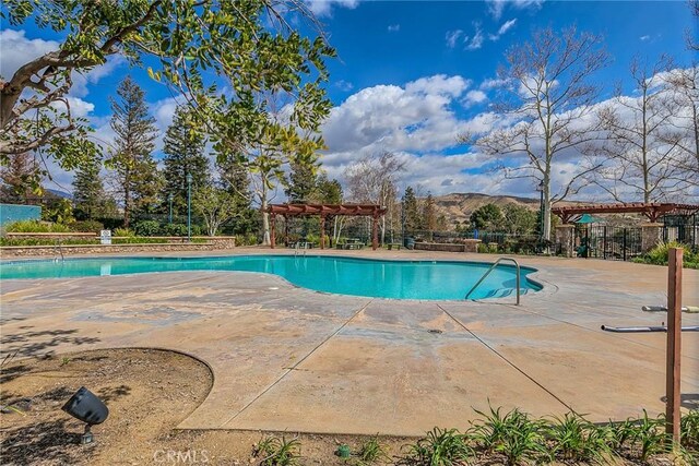 view of swimming pool featuring a patio, a mountain view, and a pergola