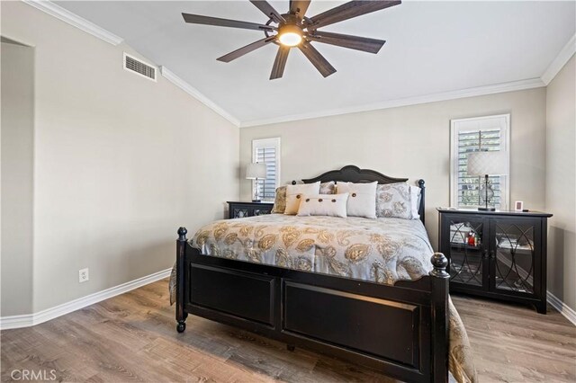 bedroom featuring ceiling fan, hardwood / wood-style floors, and multiple windows