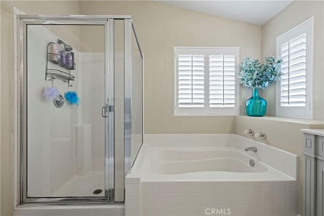 bathroom featuring independent shower and bath, vanity, and vaulted ceiling