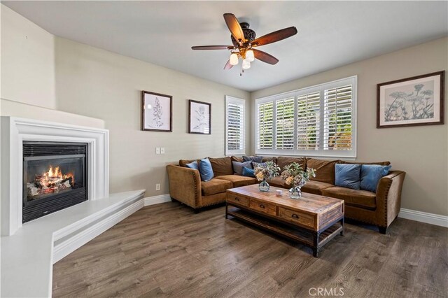 living room featuring ceiling fan and dark hardwood / wood-style flooring