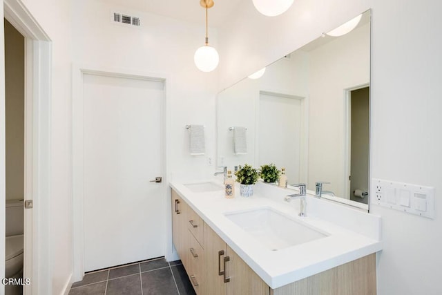 bathroom featuring vanity, tile patterned floors, and toilet