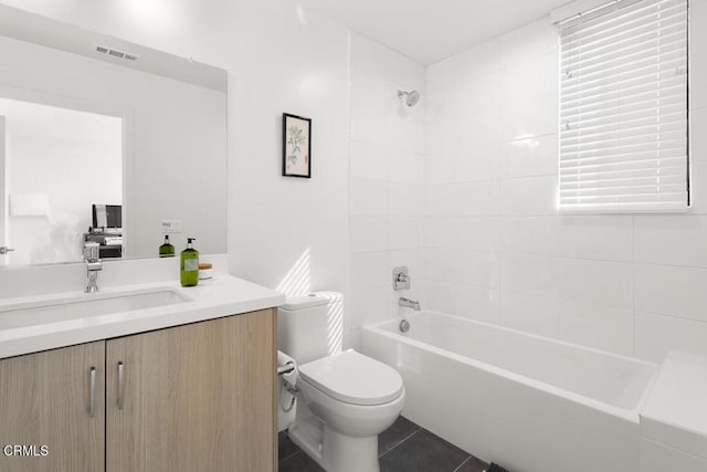 full bathroom featuring tile patterned floors, vanity, toilet, and tiled shower / bath combo