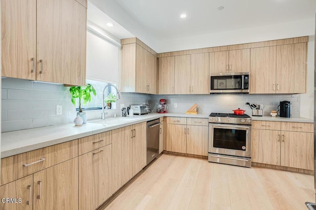 kitchen with backsplash, stainless steel appliances, sink, and light brown cabinets