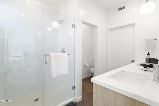 bathroom with tile patterned floors, vanity, toilet, and an enclosed shower