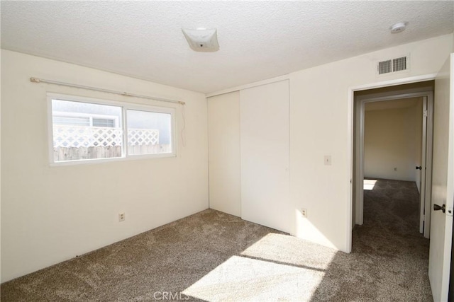 spare room featuring carpet floors and a textured ceiling