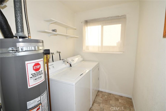 clothes washing area featuring gas water heater and separate washer and dryer