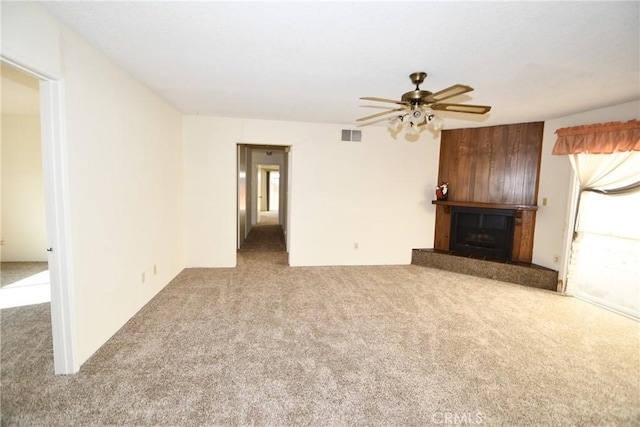 unfurnished living room featuring light carpet, a wealth of natural light, and ceiling fan