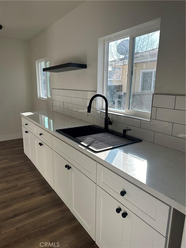 kitchen featuring backsplash, dark hardwood / wood-style floors, sink, and white cabinets