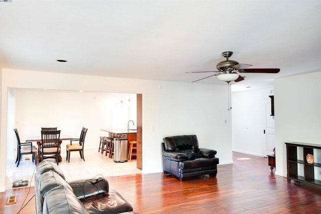 living room featuring hardwood / wood-style floors, sink, and ceiling fan