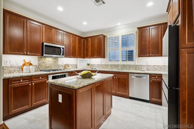 kitchen featuring sink, ornamental molding, a center island, stainless steel appliances, and light stone countertops