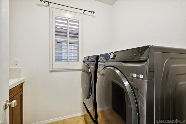 clothes washing area with cabinets and independent washer and dryer