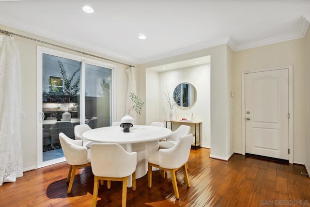 dining space featuring crown molding and dark wood-type flooring