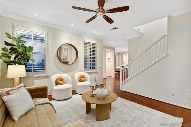 living room featuring ceiling fan, ornamental molding, and wood-type flooring